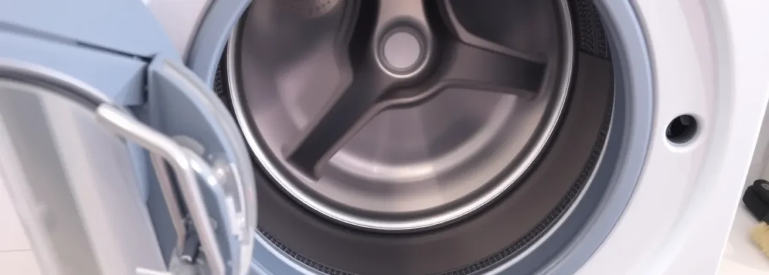 Open front-loading washing machine showing drum, gasket, pump filter, brush, wrench on countertop
